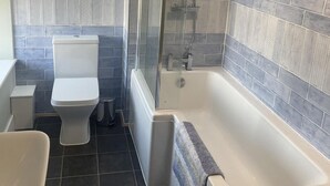 Ein Badezimmer mit Badewanne, Toilette und Dusche.