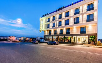 Un hotel con fachada moderna, varios pisos y un letrero de neón llamativo.