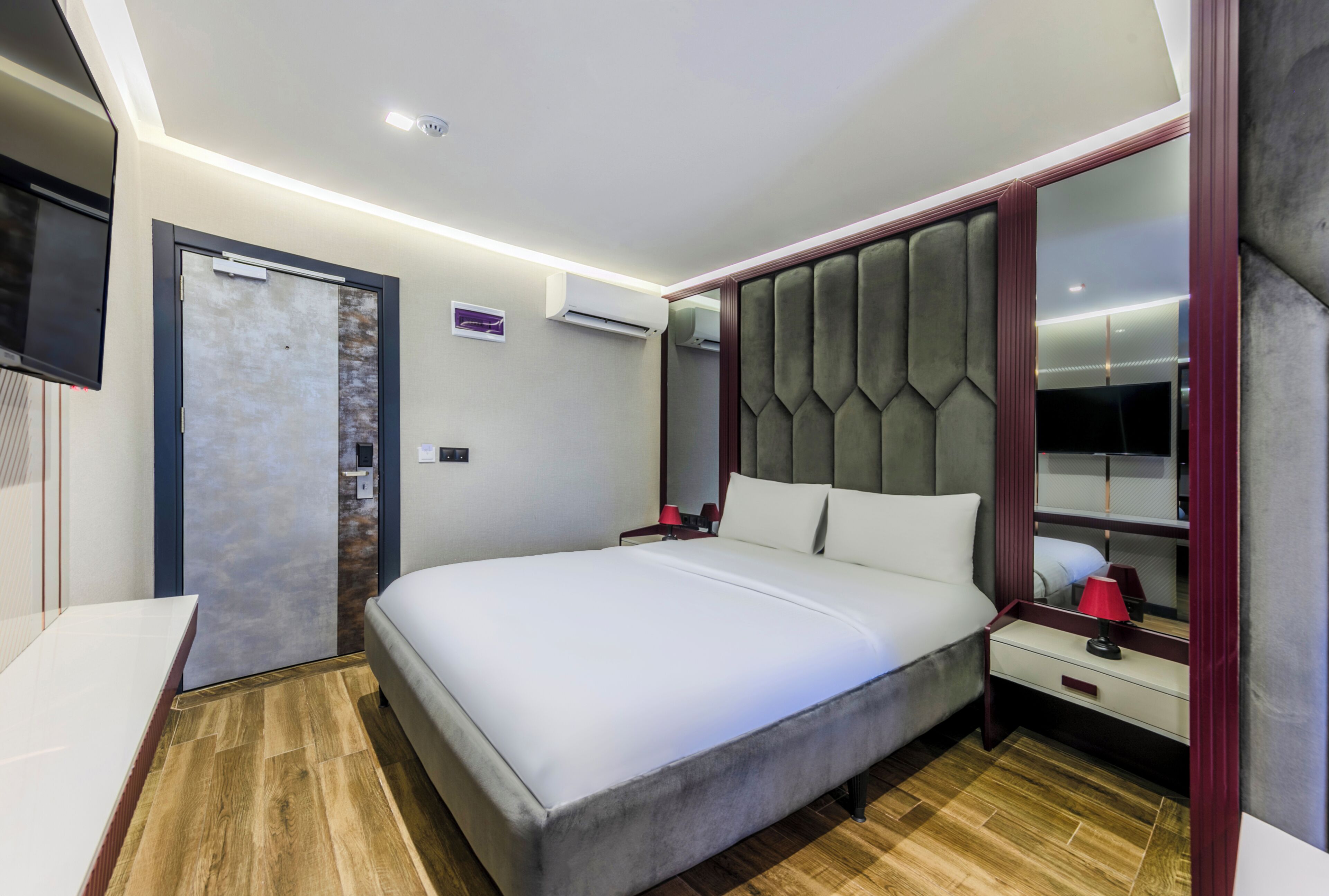 Une chambre d’hôtel moderne avec un grand lit, un bureau et un miroir.