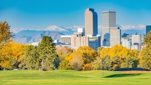 A cityscape with modern buildings and a mountain range in the background. - Trendy Denver - Fireplace/Game Room (Denver)