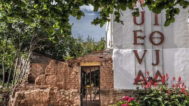 A rustic building with a stone facade and a large sign with letters.