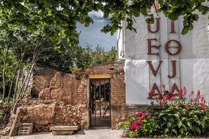 Um edifício rústico com fachada de pedra e um letreiro grande com letras.