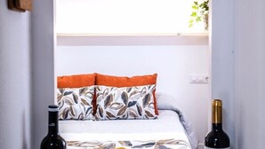 A cozy room with a bed, a bowl of fruit, and two wine bottles. - A garden among vineyards, for 6 (Uruñuela)