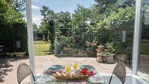 A table set for breakfast with a view of a garden through a glass door. - A garden among vineyards, for 6 (Uruñuela)