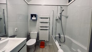 Ein modernes Badezimmer mit Toilette, Waschbecken und Dusche.