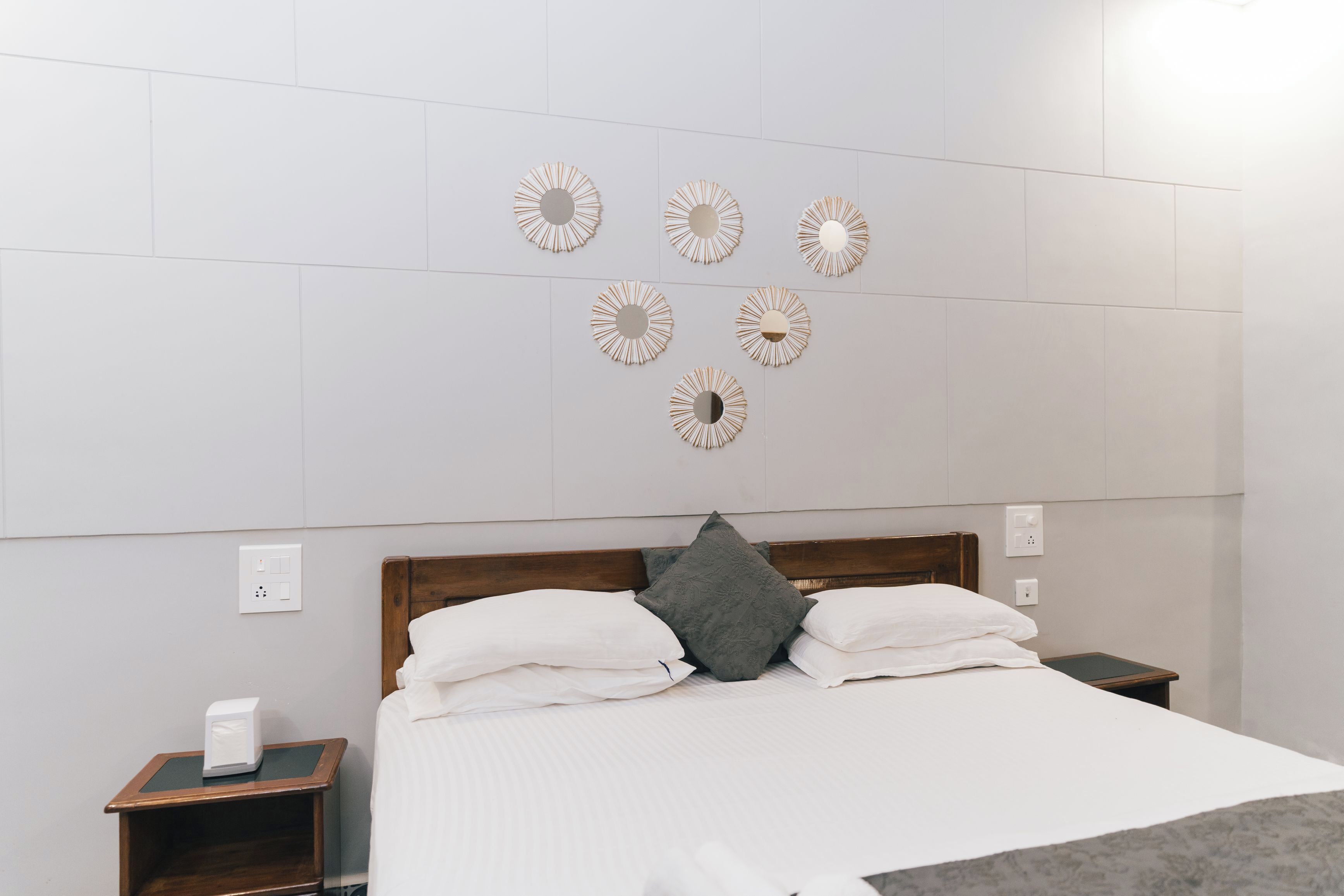Une chambre d’hôtel comprenant un lit, une table de chevet et des éléments décoratifs fixés au mur.