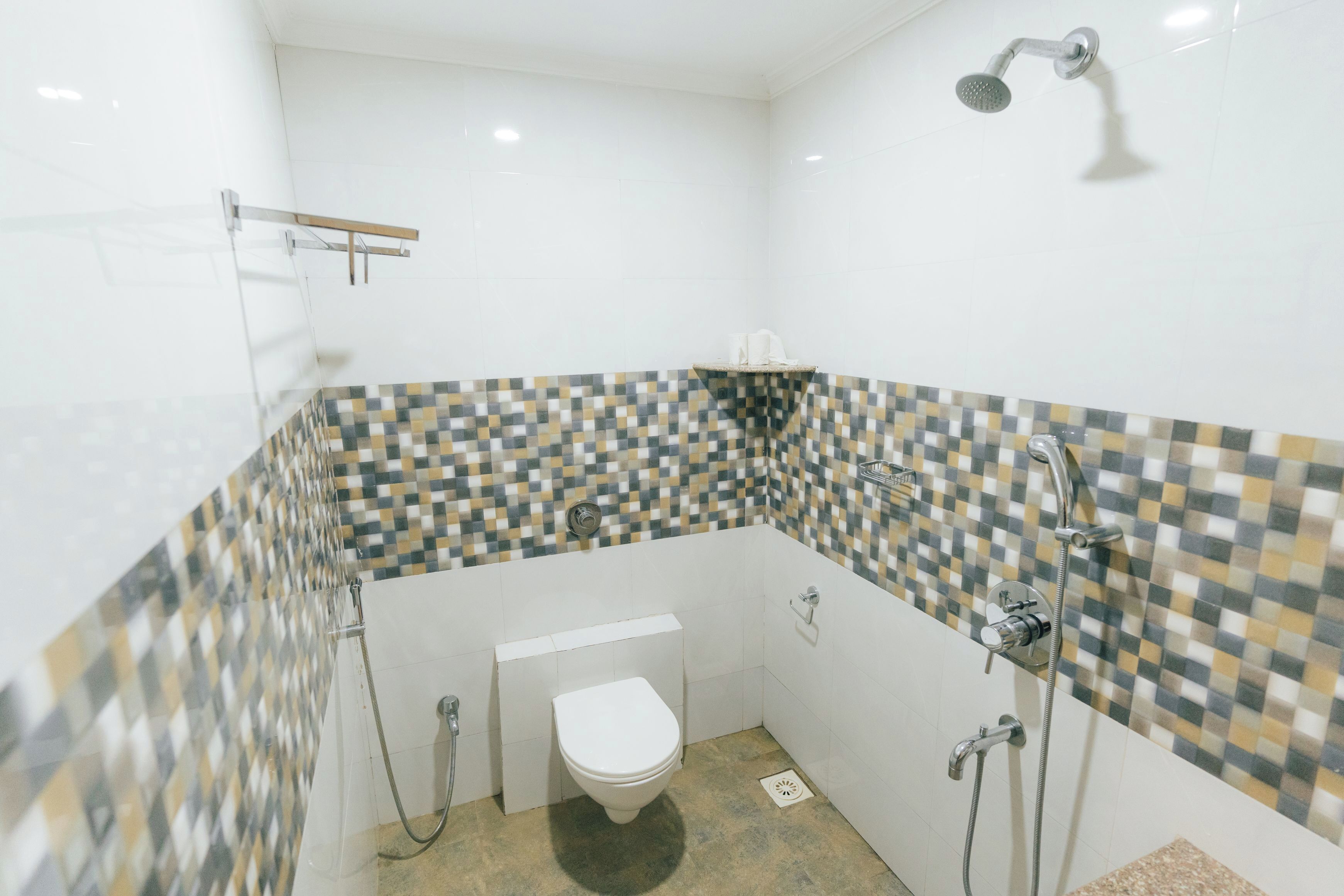 Un baño pequeño con azulejos, que incluye inodoro, ducha y lavamanos.