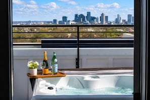 A balcony with a hot tub, two bottles of champagne, and a potted plant. - Nashville Duo Retreat • Private Rooftops (Nashville)