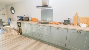 Una cocina moderna con una isla central, electrodomésticos integrados y un amplio ventanal.