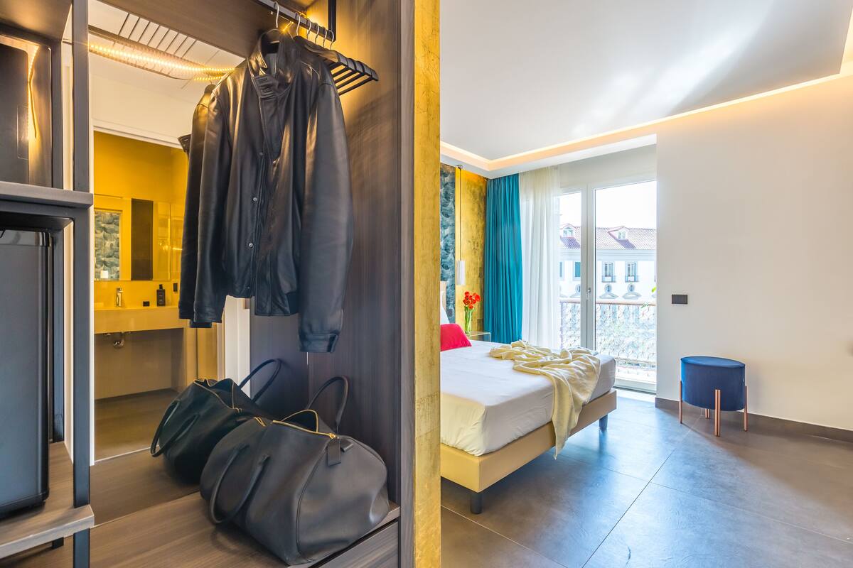 Una habitación de hotel moderna con cama, armario y zona de estar.