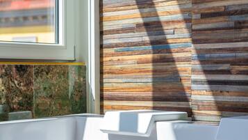 Bathroom features a unique panel wall design, two sinks, and a large window.