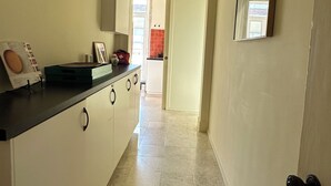 A hallway with a kitchen area, a door leading to another room, and a tiled floor. - Eco Luxury apartment Campo de Ourique LISBON center (Lisboa)