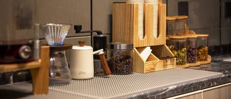 A coffee station with a coffee grinder, a coffee pot, and a coffee cup.