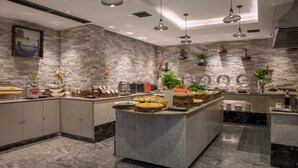 Una cocina moderna con protector contra salpicaduras de piedra, encimeras de mármol y un espacio tipo bufé.