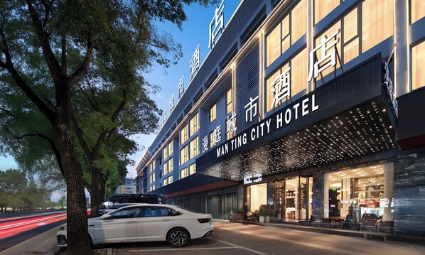 A hotel with a large sign reading "MAN TING CITY HOTEL" and a visible entrance with glass doors. - Yiwu  Manting City Hotel (Jinhua)