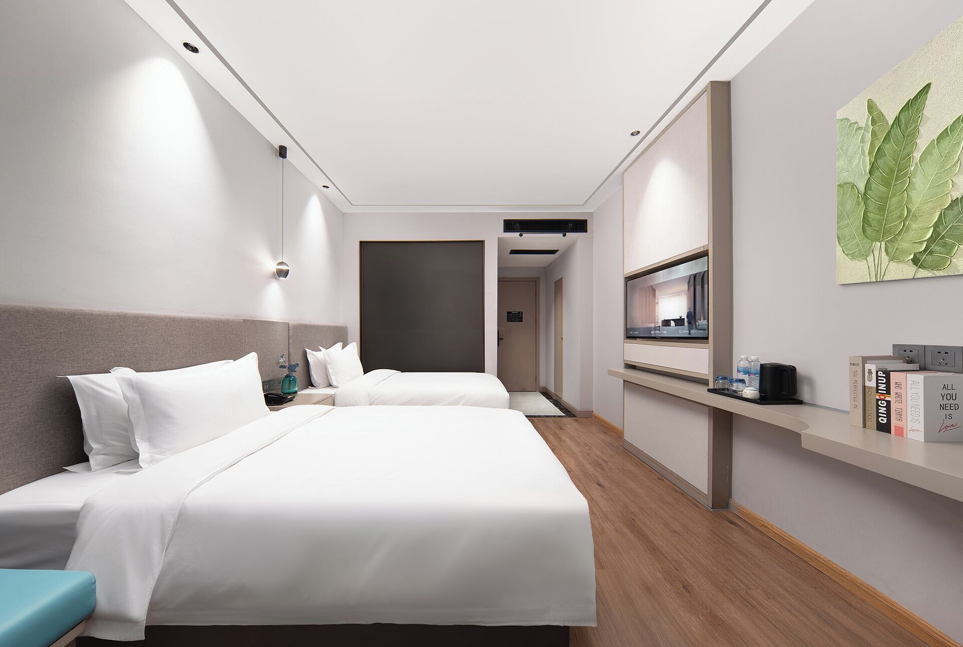 A hotel room with a large bed, bedside tables, a desk with a computer, and a mirror.
