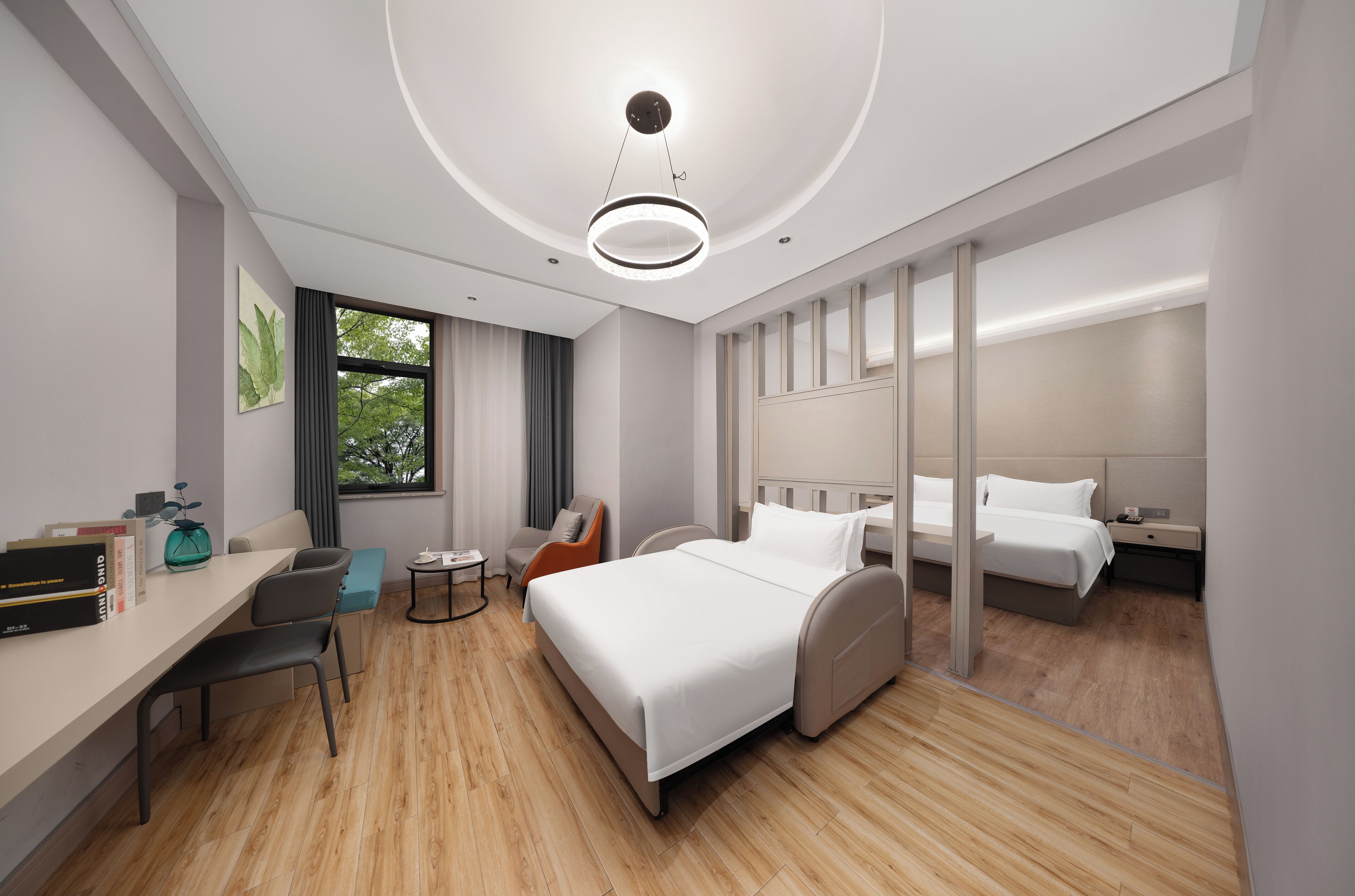 Une chambre d’hôtel moderne avec un grand lit, un bureau, une chaise et une petite table.