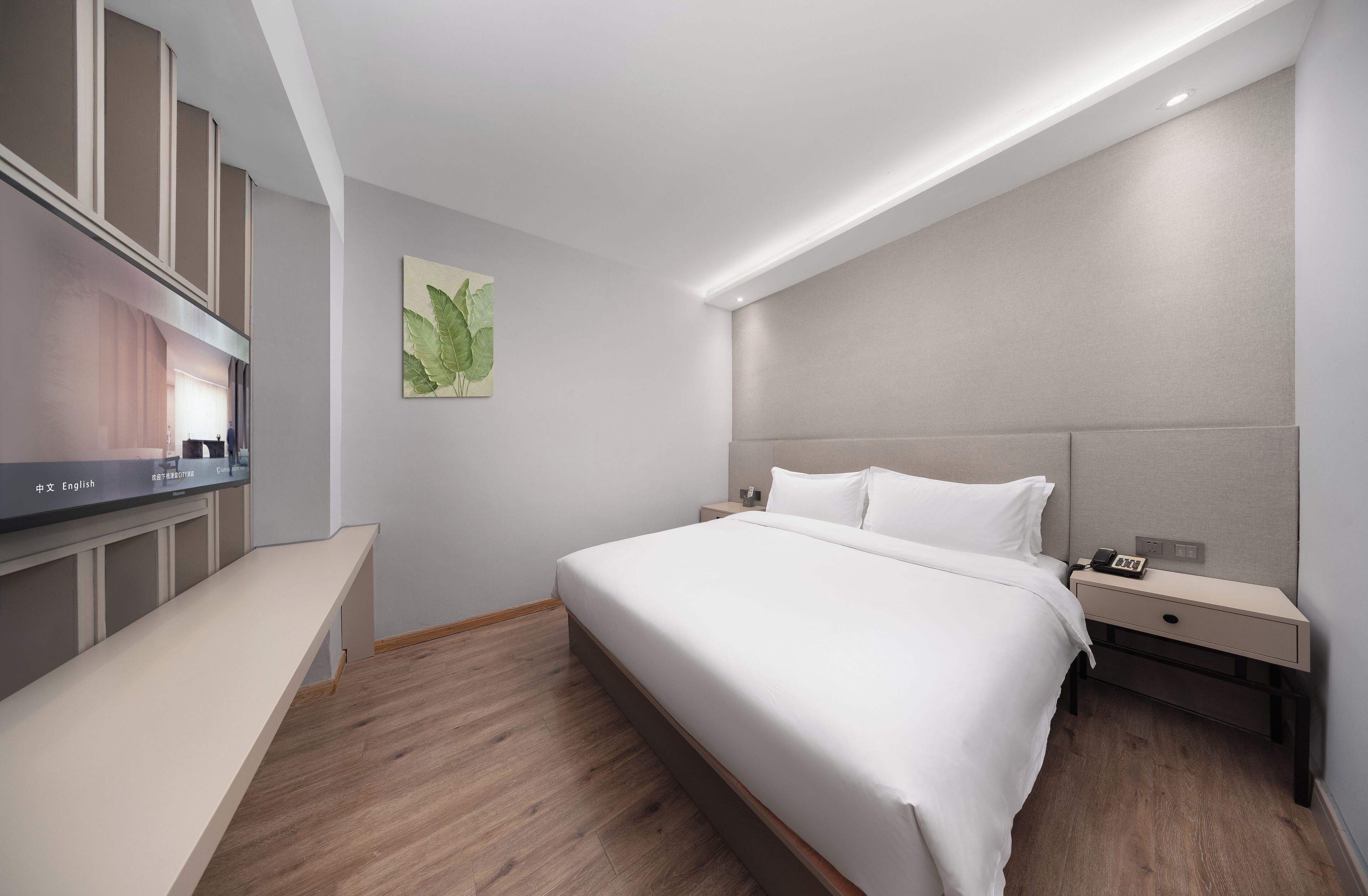 Una habitación de hotel moderna con una cama grande, mesitas de noche, un televisor de pantalla plana y un banco.