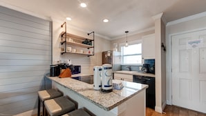 A modern kitchen with a granite countertop, built-in shelves, and a refrigerator. - Recently remodeled 3br condo at Bay Tree!  Stellar Old Town Port Aransas locatio (Port Aransas)