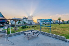 A beachfront condominium complex with a clear view of the ocean, a picnic table, and a sign for Baytree Condominiums. - Bright, spacious studio with balcony, king-size bed plus Murphy bed, full kitche (Port Aransas)