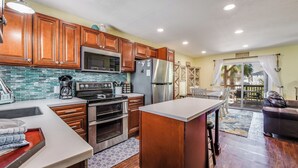 A modern kitchen with wooden cabinets, stainless steel appliances, and a large island. - Bay Tree B11/12 offers a top notch location near the community pool, lighted fis (Port Aransas)
