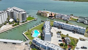 A marina with boats, a swimming pool, and buildings with balconies. - Bay Tree B11/12 offers a top notch location near the community pool, lighted fis (Port Aransas)