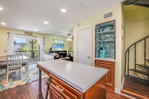 A spacious kitchen with a large island, wooden cabinets, and a view of the outdoors. - Bay Tree B11/12 offers a top notch location near the community pool, lighted fis (Port Aransas)