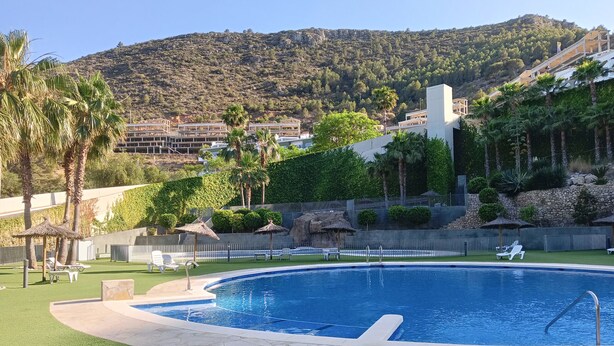 A swimming pool with a view of a mountainous landscape, surrounded by palm trees and lounge chairs. - Xeresa del Monte 85 Only Families! (Xeresa)