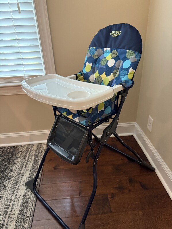 A high chair with a colorful pattern and a tray.
