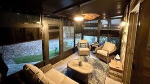 Un espace patio accueillant, avec des meubles en osier, une table ronde et une vue sur un paysage enneigé.