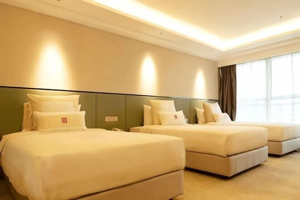 A hotel room with two beds, a large window, and a modern design.