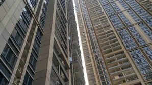 A high-rise building with multiple floors, large windows, and balconies.