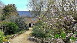 A stone house with a gravel path leading to a wooden door.