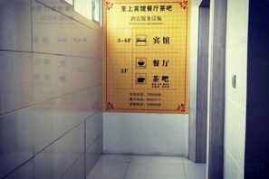 Pasillo con un cartel que indica la ubicación del restaurante y la casa de té en los pisos tercero y segundo.
