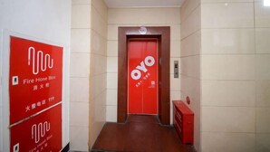 A hallway with a red fire hose box and a door with the "OYO" logo. - Taoyuan Supreme Hotel (Taoyuan)