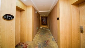 A narrow hallway with wooden walls and a patterned carpet. - Taoyuan Supreme Hotel (Taoyuan)