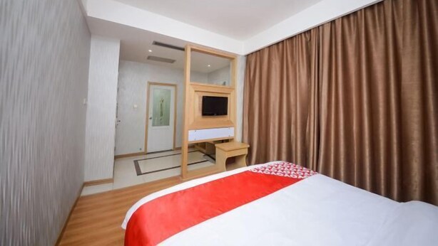A hotel room with a bed, a television, a desk, and a mirror. - Taoyuan Supreme Hotel (Taoyuan)