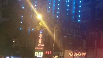 A nighttime city street with illuminated signs and buildings.