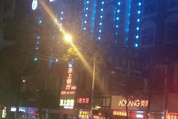 A nighttime city street with illuminated signs and buildings. - Taoyuan Supreme Hotel (Taoyuan)