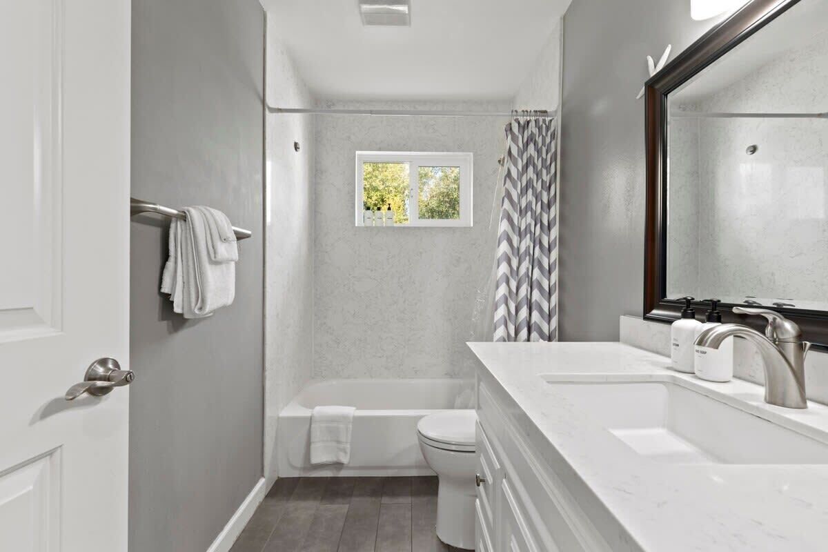 Bathtub, hair dryer, towels, shampoo