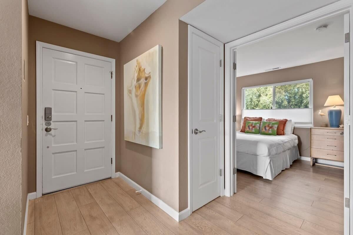 Un dormitorio con cama, ventana y mesita de noche.