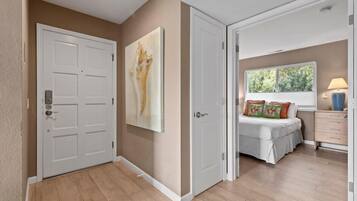 Un dormitorio con cama, ventana y mesita de noche.