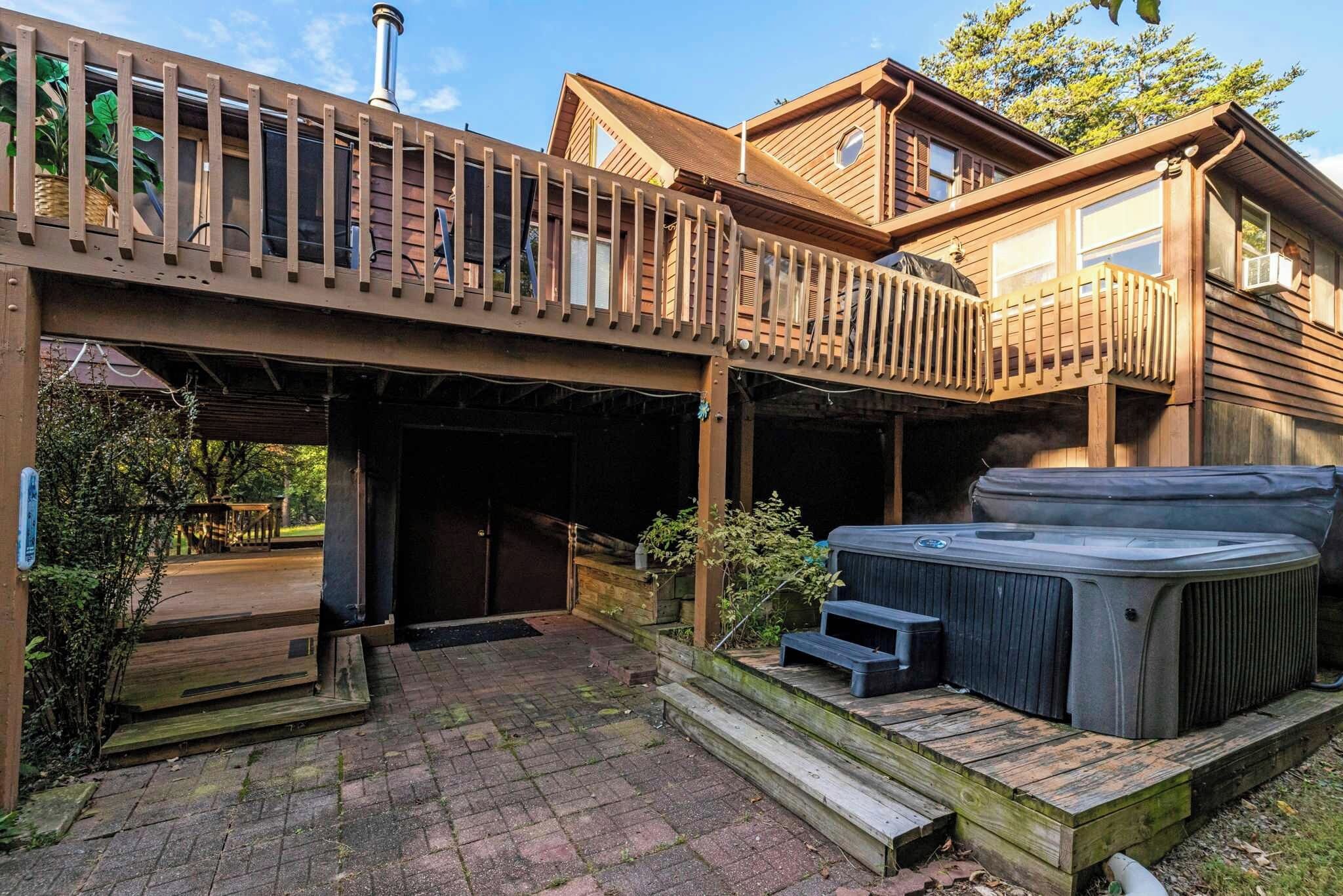 Une terrasse en bois avec des bains à remous et un espace abrité.