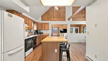 A kitchen with wooden cabinets, a central island, and a built-in oven.
