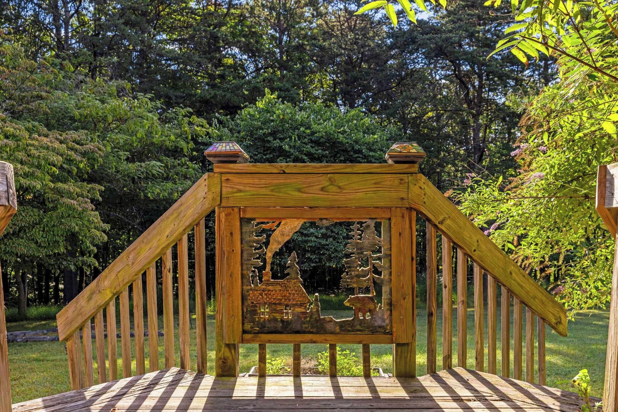 Un pontile di legno con un motivo decorativo raffigurante una casa e degli alberi.