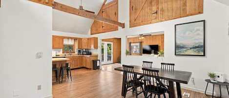 A spacious kitchen with wooden cabinets, a dining area with a large table and chairs, and a view of the outdoors.