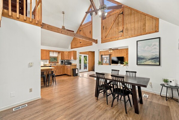 A spacious kitchen with wooden cabinets, a dining area with a large table and chairs, and a view of the outdoors.