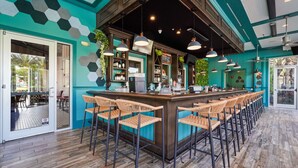 A bar area with a long counter, multiple bar stools, and pendant lighting. - Blue Harbour Retreat: Private Pool, Free BBQ Grill (Davenport)
