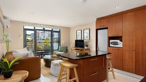 Een moderne keuken met houten kastjes, een zwart aanrecht en een ingebouwde magnetron.