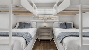 Un dormitorio con literas, una mesita de noche y una ventana con vistas.
